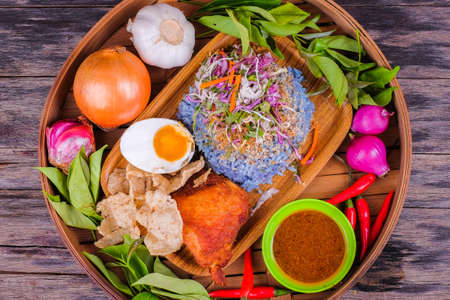 Fried chicken with rice and a combination of vegetables, duck eggs and ingredients in the basketの写真素材