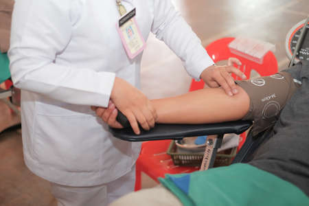 Muadzam Shah,  Malaysia - February 21st, 2018 : Unidentified hospital staff arms sticking needle into male arm during blood donation campaign .のeditorial素材