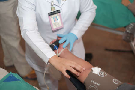 Muadzam Shah,  Malaysia - February 21st, 2018 : Unidentified hospital staff arms sticking needle into male arm during blood donation campaign .のeditorial素材