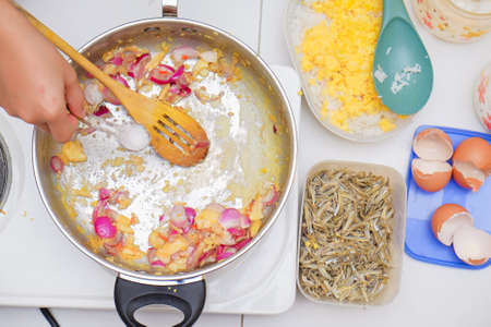Young asian boy stirring ingredients for cooking homemade spicy fried riceの写真素材