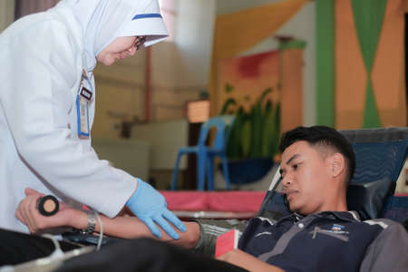 Muadzam Shah,  Malaysia - February 21st, 2018 : Unidentified hospital staff holding blood pint donated by volunteer donor during blood donation campaign.のeditorial素材