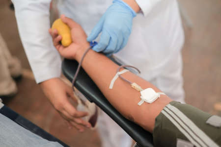 Muadzam Shah,  Malaysia - February 21st, 2018 : Unidentified hospital staff arms sticking needle into male arm during blood donation campaign .のeditorial素材