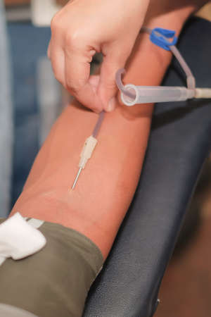 Muadzam Shah,  Malaysia - February 21st, 2018 : Unidentified hospital staff arms sticking needle into male arm during blood donation campaign .のeditorial素材