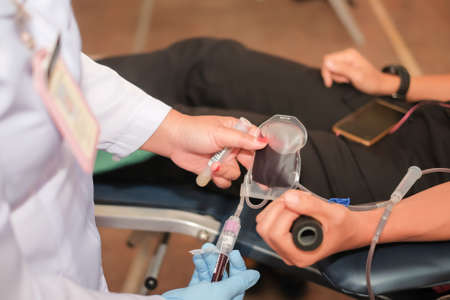 Muadzam Shah,  Malaysia - February 21st, 2018 : Unidentified hospital staff arms sticking needle into male arm during blood donation campaign .のeditorial素材