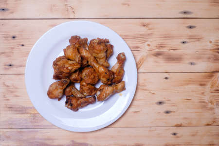 Fried chicken on white plate over the wooden tableの写真素材