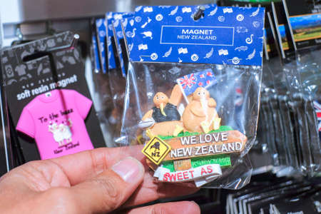Christchurch, New Zealand  December 19th, 2017 : Man holding  New Zealand fridge magnet souvenir in DP Souvenir shop at Christchurch, New Zealand.のeditorial素材