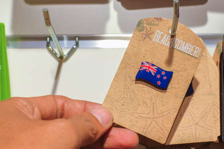 Christchurch, New Zealand  December 19th, 2017 : Man holding New Zealand flag souvenir fridge magnet in DP Souvenir shop at Christchurch, New Zealand.のeditorial素材