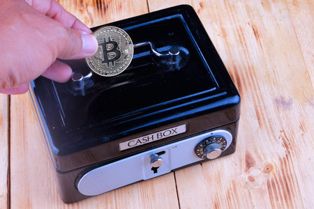 Cash box , hand holds golden bitcoin coin virtual money. Cryptocurrency and saving concept