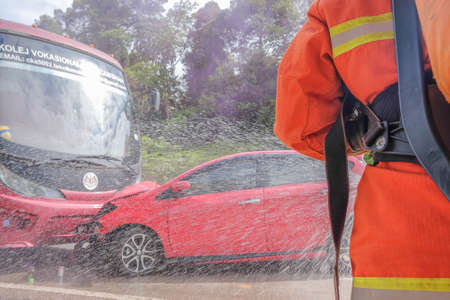 Muadzam Shah, Pahang - October 18th, 2018 : Fireman using water and extinguisher to fighting with fire flame in an emergency situation during road accidents in  Inter Agency Disaster Training Program 2018 .のeditorial素材