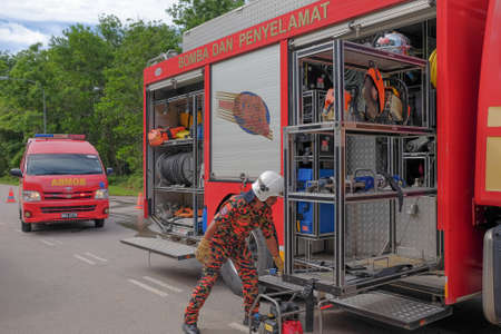 Muadzam Shah, Pahang - October 18th, 2018 : Fireman using water and extinguisher to fighting with fire flame in an emergency situation during road accidents in  Inter Agency Disaster Training Program 2018 .のeditorial素材