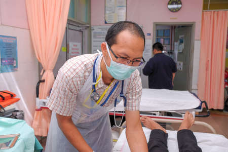 Muadzam Shah, Pahang - October 18th, 2018 : A male doctor who is examining female patients lying on the patient's bed during road accidents in  Inter Agency Disaster Training Programのeditorial素材