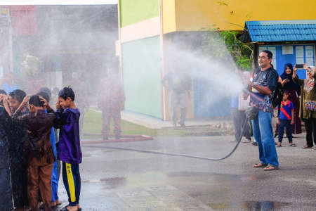 Muadzam Shah, Malaysia -  November 24th  , 2018 : Childrens wearing traditional malay costume are happy to play the water during the flush event of the circumcision participants.のeditorial素材