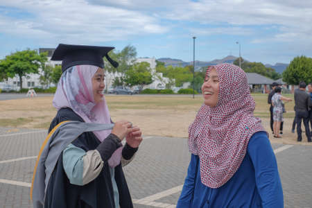 Christchurch, New Zealand - Disember 15th, 2017 : Beautiful Asian female Muslim wearing a convocation robe and posed in happiness before a graduation ceremony at University of Canterburyのeditorial素材