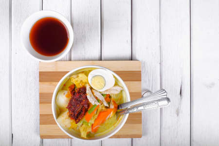 Lontong-Traditional Malaysian and   Indonesian food on wooden table with spoon.の写真素材