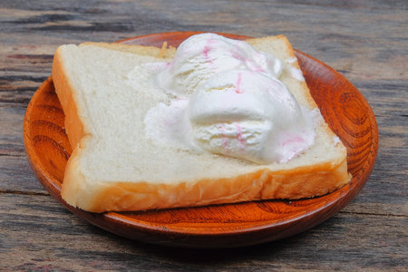 Strawberry and vanilla ice cream on wooden plate .
