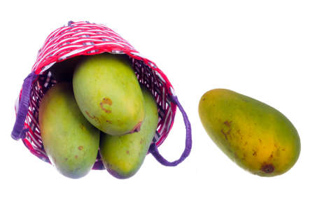 Unripe mangoes in a basket  isolated on white backgroundの写真素材