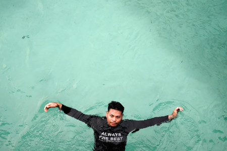 Perhentian  Island , Malaysia - August 15th, 2018 :Top view of sea diver  in a water suit is swimming with   fishのeditorial素材