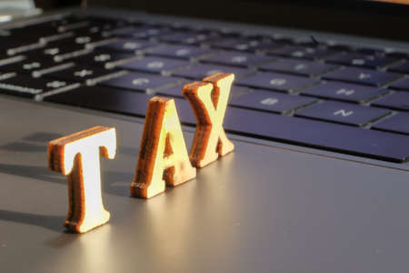 TAX  word with shadow on laptopの写真素材