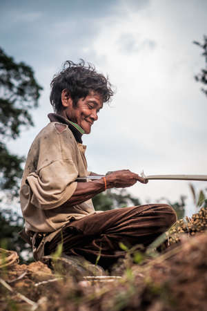 Muadzam Shah, Malaysia - March 12th, 2019 : Men of the Orang Asli split Kayu  Bertam using a knife. Bertam is a kind of palm tree found in Malaysian and Thai . His botanical name Eugeissona tristis.のeditorial素材