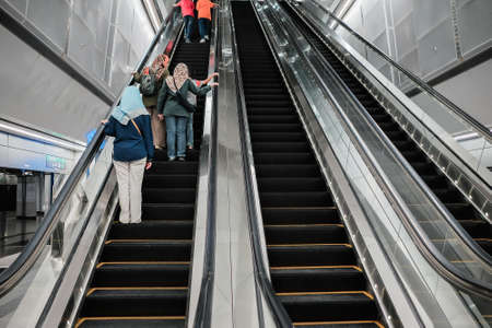 KUALA LUMPUR, MALAYSIA - December 31st ,  2017: Asian Malay mother with  son and daughters taking escalator at MRT Station . MRT is Mass Rapid Transit Corporation Sdn Bhd, in Kuala Lumpur, Malaysia.のeditorial素材