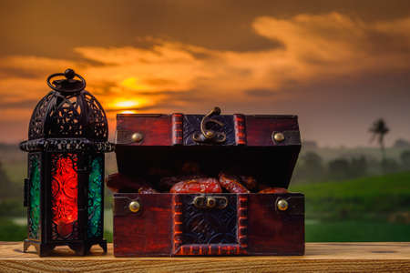 Lighting Ramadan Lantern  and  dates    on old wood with a beautiful sunrise as background. Holy month of Ramadan concept.の写真素材