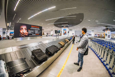 Sepang, Malaysia - Disember 21st, 2017 : Passengers collecting luggage at conveyor belt in Kuala Lumpur International Airport.のeditorial素材