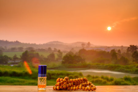 Ramadan kareem concept with rosary, and perfume on old wood with beautiful sunrise  as background