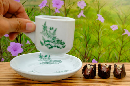 A cup of coffee using vintage cup with chocolate almond london  and sunshine in the morning.