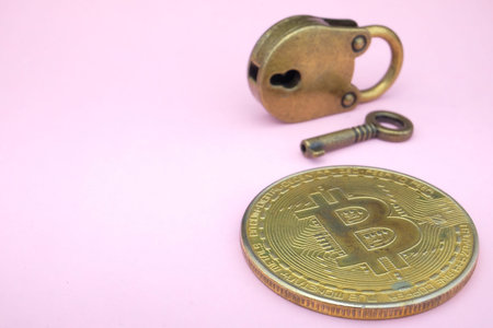Bitcoin security concept. Gold coin with padlock on pink paper