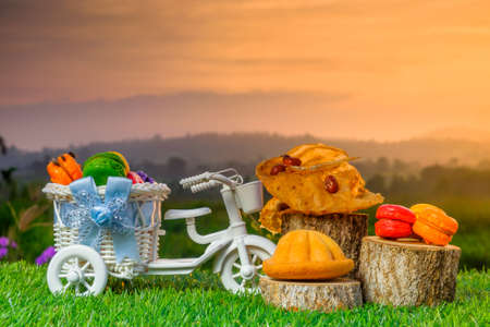 Malaysia traditional sweet as known as Baulu or Bahulu and Rempeyek with Macaron  on wooden sliced  during beautiful sunrise.の写真素材