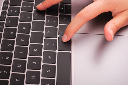 Woman hand working at home office on modern laptop keyboard.