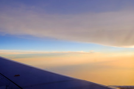 Flying and traveling, view from airplane window on the wing on sunset timeの写真素材