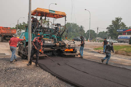 Ayer Hitam, Malaysia - September 22nd , 2019 : Workers making asphalt with shovels at road constructionのeditorial素材