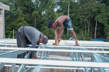 Muadzam Shah, Malaysia - October 8th, 2019 : Construction workers installing metal roof trusses at...