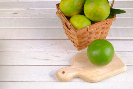 Oranges in a basket  on white tableの写真素材