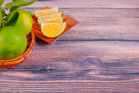Citrus fruits with green leaves isolated on wood backgroundの写真素材
