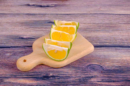 Sliced of citrus fruits on wood backgroundの写真素材