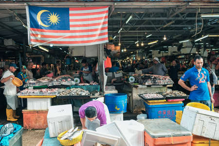 Kuala Lumpur, Malaysia - December 2nd, 2019 :  A wet market selling different colorful fishes with people buying in the morning .のeditorial素材