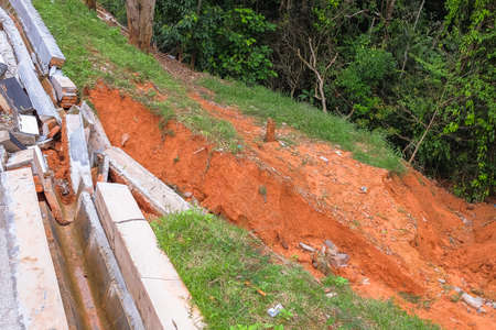 Drain damage. Soil erosion or landslide  in the slope  during  the rainy season at Muadzam Shah, Malaysia.の写真素材