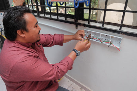 Muadzam Shah, Malaysia - July 12th, 2019 : The hands of an electrician installing a power socket.のeditorial素材