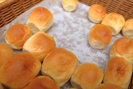Lots of fresh bread in a basket on a tableの写真素材