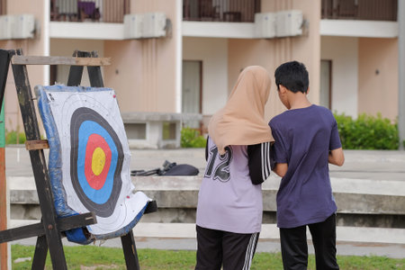 Kuala Rompin, Malaysia- December 29th, 2019 : Young boy and girl standing besides the bull's eye of...