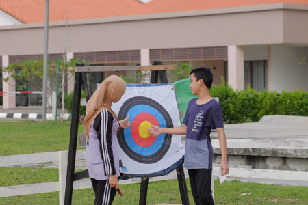 Kuala Rompin, Malaysia- December 29th, 2019 : Young boy and girl standing besides the bull's eye of...