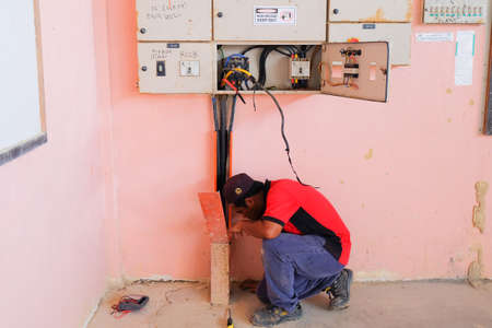 Muadzam Shah, Malaysia - January 31th, 2020: Technician wiring cable in front of electrical panel for control and distribute electrical power system in building.のeditorial素材