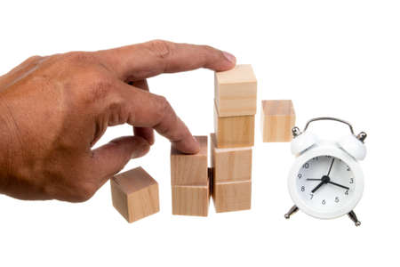 Hand holding blank wooden cubes with  white alarm clock . Business concept background, mock up, templateの写真素材