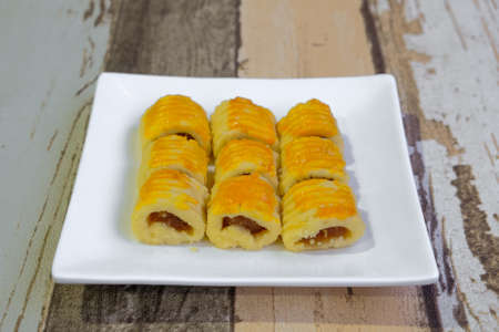 Closeup of traditional snack during Hari Raya Aidilfitri in Malaysia called kuih tart or pineapple tart on the white wooden background.の写真素材