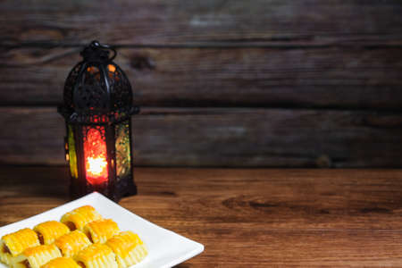 Closeup of traditional snack during Hari Raya Aidilfitri in Malaysia called kuih tart or pineapple tart and lantern on the wooden background.の写真素材