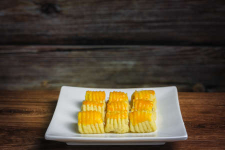 Closeup of traditional snack during Hari Raya Aidilfitri in Malaysia called kuih tart or pineapple tart on the white wooden background.の写真素材