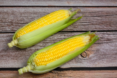 Fresh corn on wooden background.
