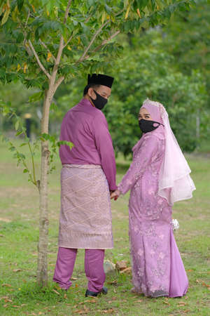 Muadzam Shah, Malaysia - May 9th,  2020 : A muslim couple getting solemnization  in medical face masks during coronavirus pandemic. COVID-19 weddings.のeditorial素材